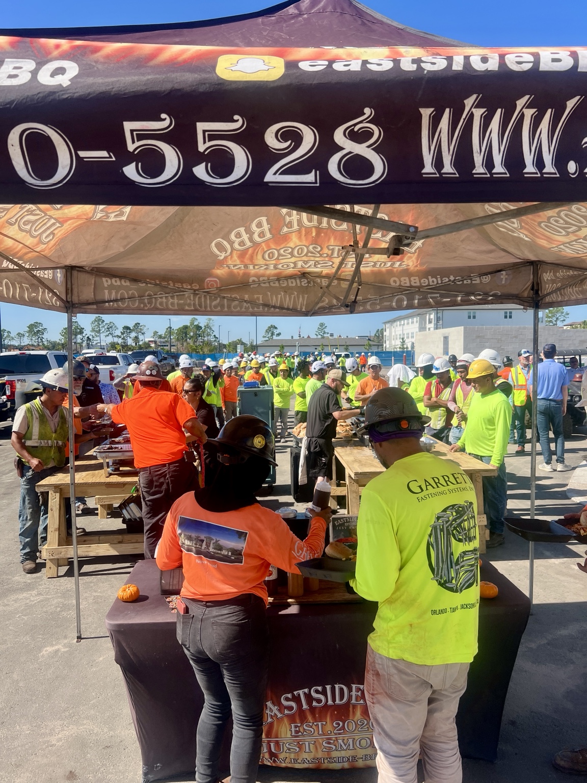 The Eastside BBQ team serving guests under our tent