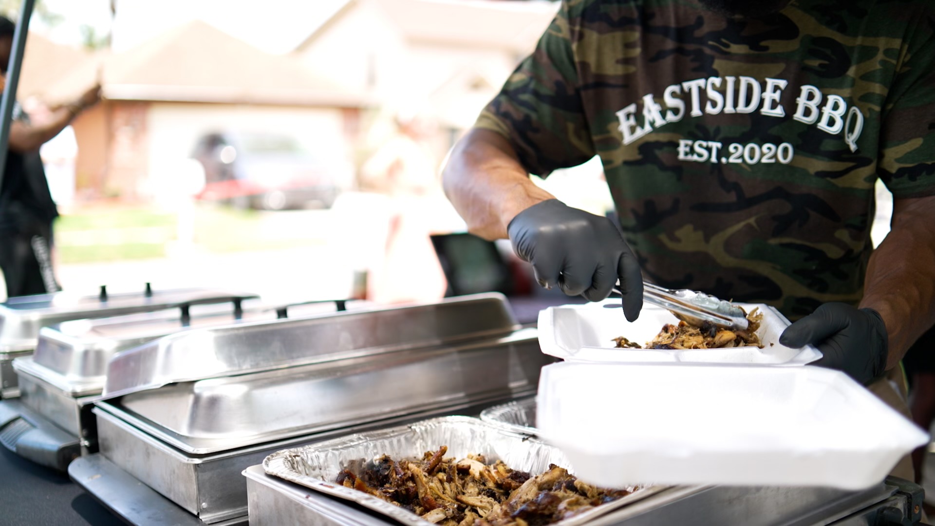 An Eastside BBQ team member serving smoked meat at an event