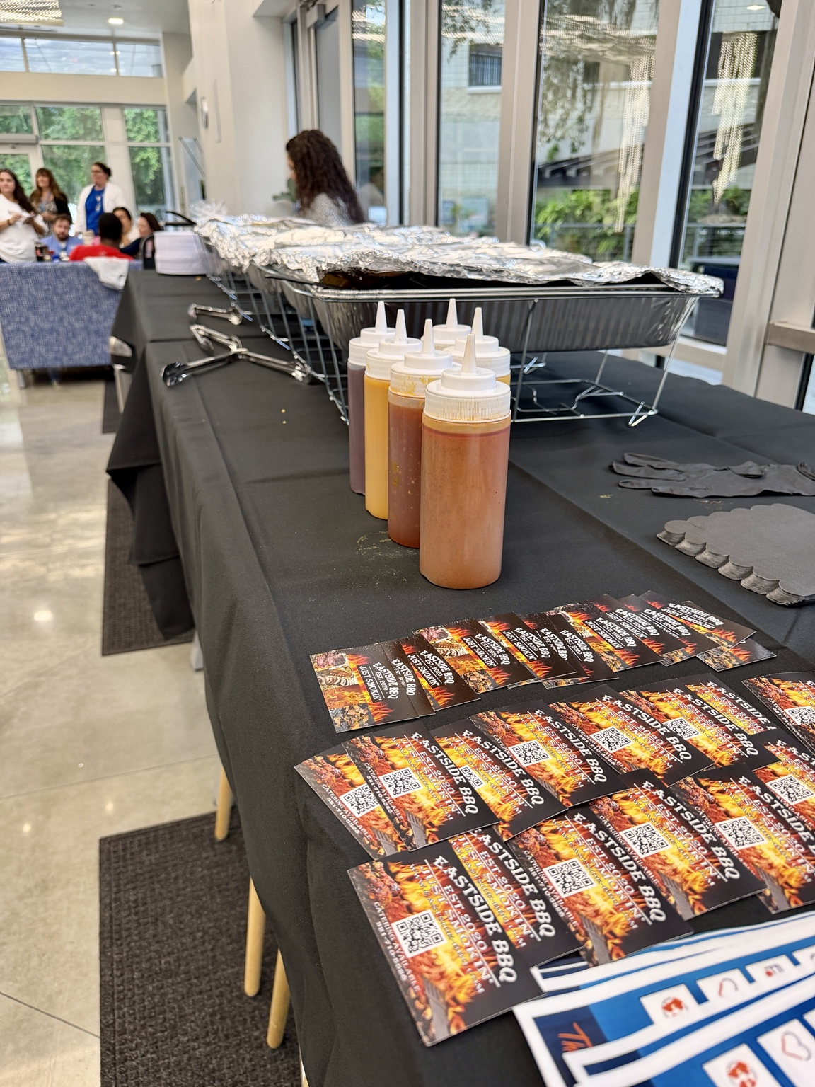 An indoor Eastside BBQ buffet with chafing dishes and barbecue sauces