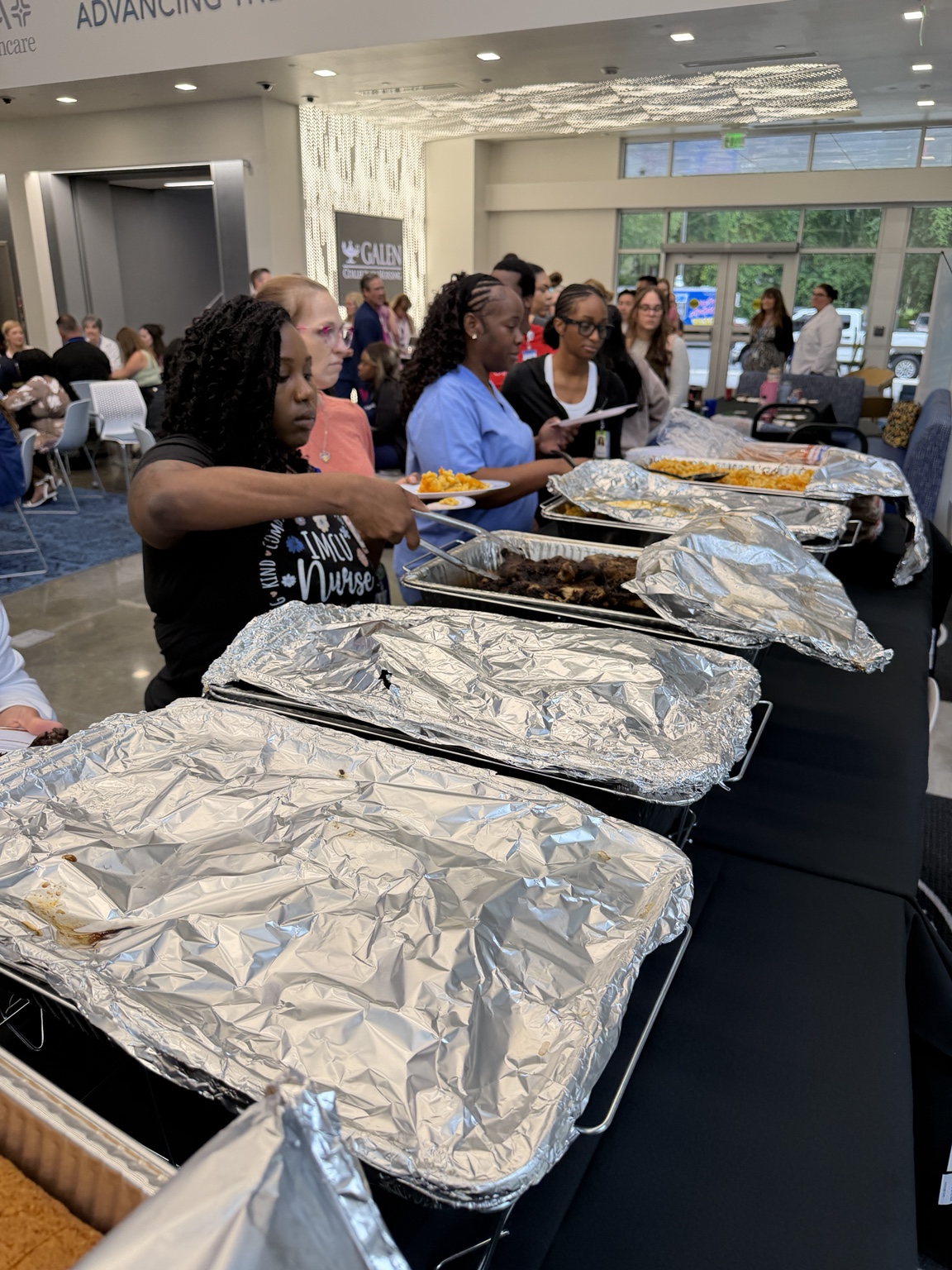 Guests gathering around an Eastside BBQ buffet at an indoor event