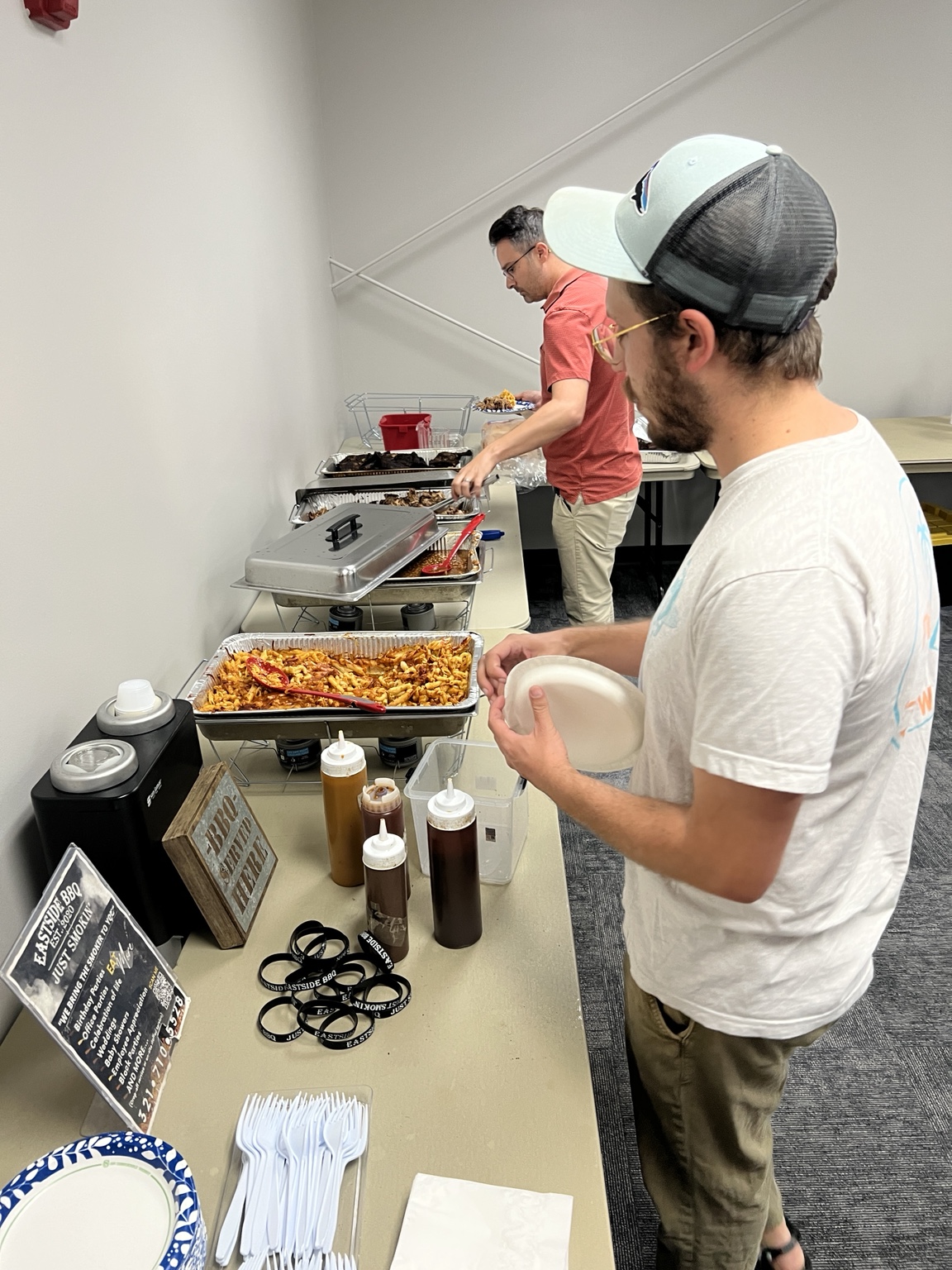 Guests enjoying a catered barbecue buffet with sides and sauces